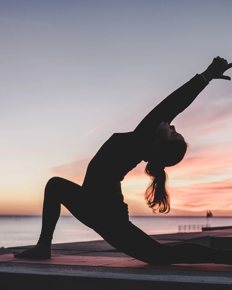 Person moving through a stretch outdoors at sunset
